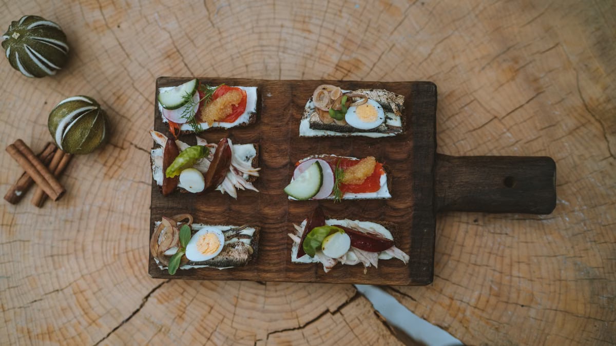 Top view of holiday appetizers on a wooden board with festive elements, creating a cozy rustic feel.